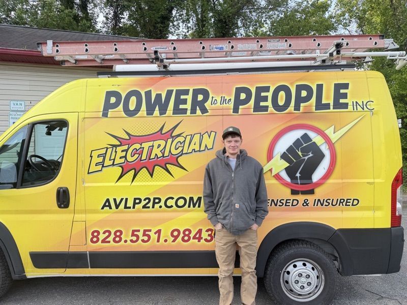 Person in a gray Carhartt jacket and ball cap, by the company van.