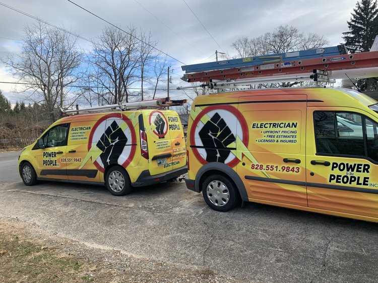 Two Power to the People branded electrician vans parked side by side, ladders on roof racks, marked Electrician — Upfront pricing — Free estimates — Licensed and insured — (828) 551-9843